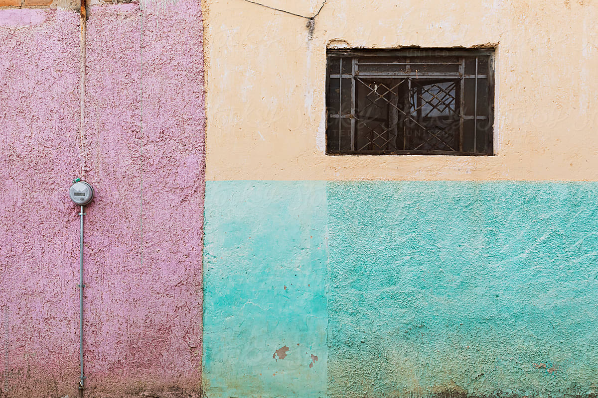 A street wall painted aqua, pink and yellow in rectangles