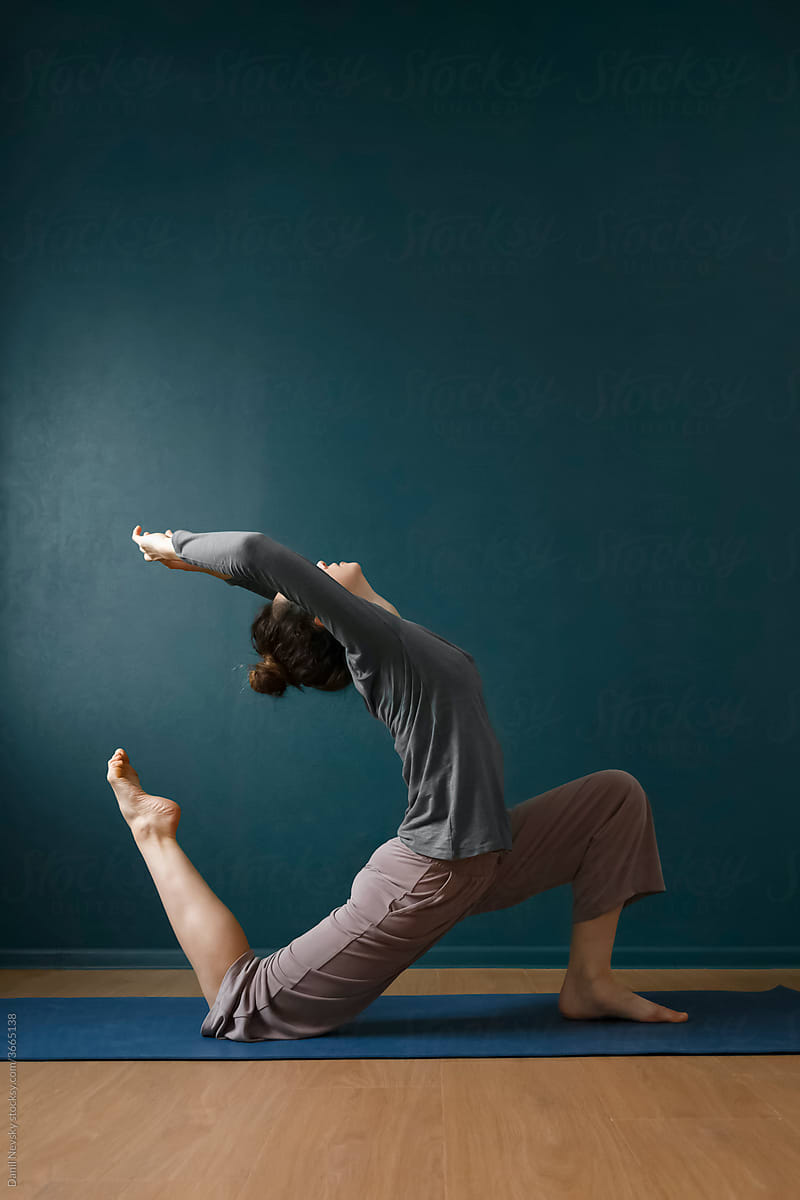 Flexible woman doing yoga in studio