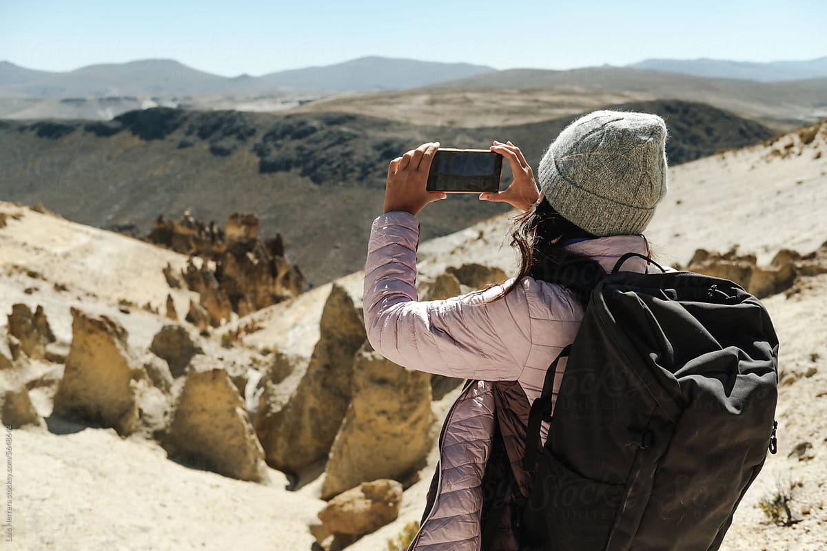 Traveller capturing picture of beautiful landscape with phone