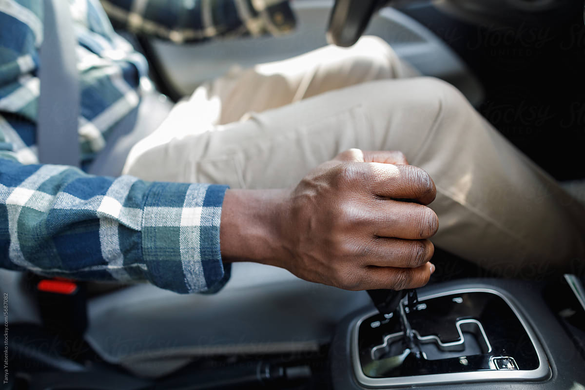Man\'s hand grabbing the gear lever in the car