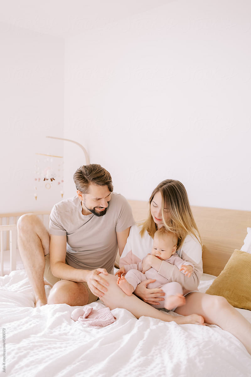 Portrait Of Parents With Baby On The Bad