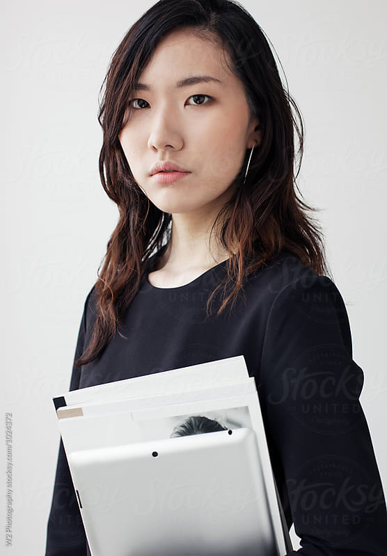 Portrait of a student holding books and a tablet pc.