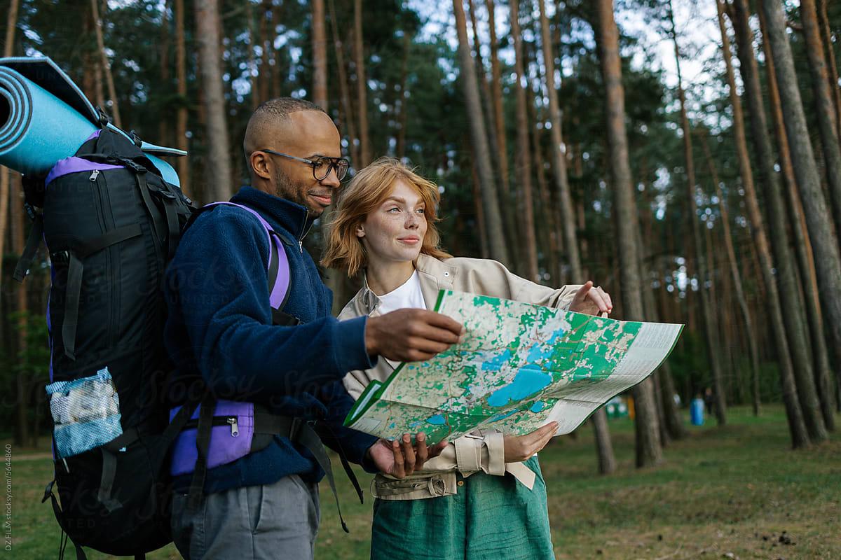 A man and a woman use the map on a hike