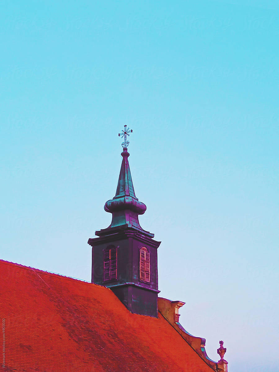 Old dome with a Christian cross on the rooftop of a medieval church.