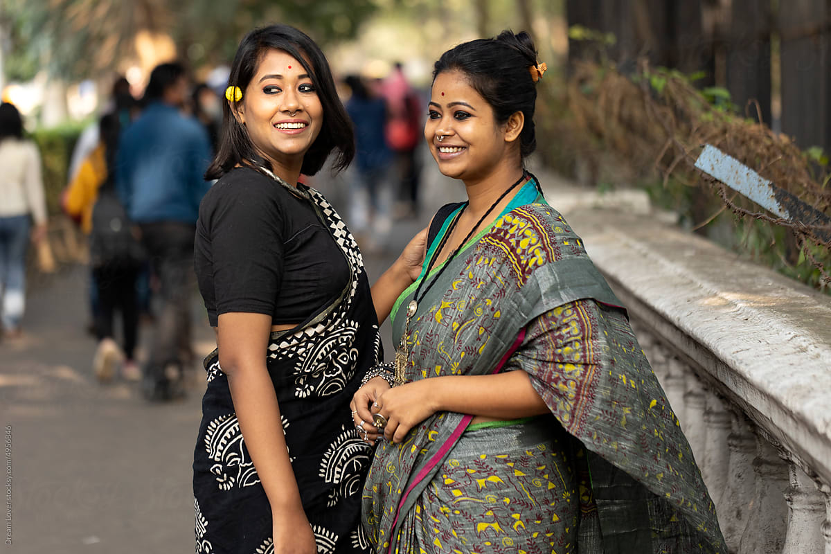 Two young woman wearing traditional sari interacting at outdoors
