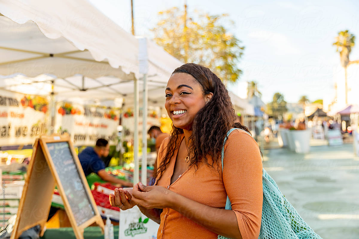 Woman Smiles At The Farmers Market By Stocksy Contributor Jayme