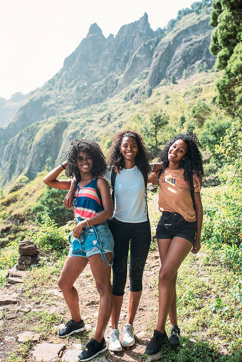 black ethnic afro sisters looking at camera while hiking