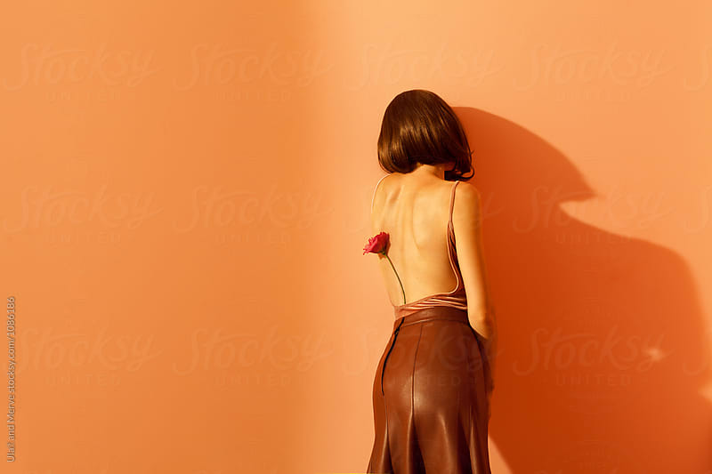 woman with long leather skirt leaning against a wall