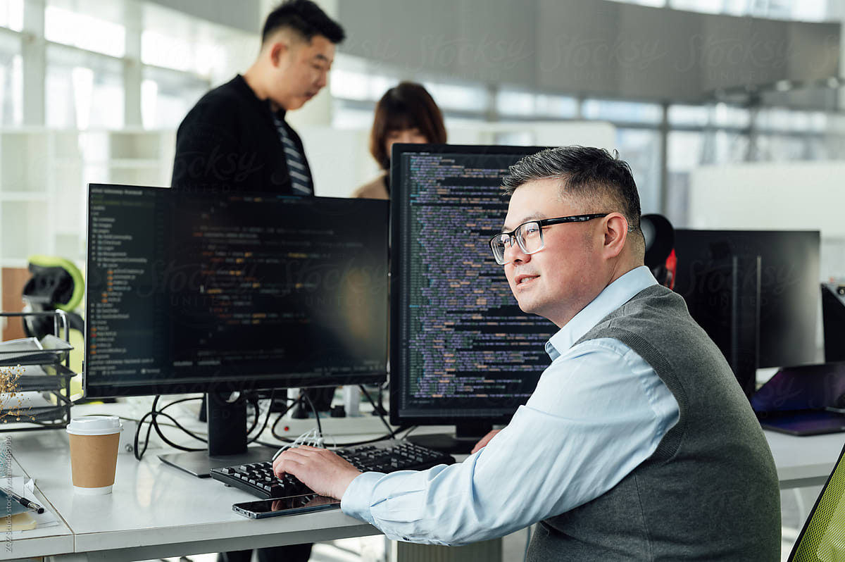 Portrait of Chinese male engineer with computer in office