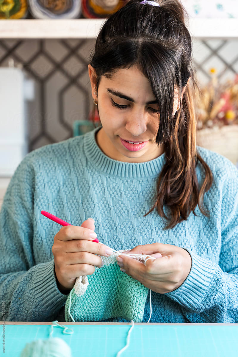 Young woman concentrating on knitting project