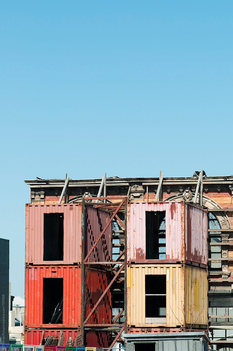 Containers and steel girders holding up a building facade, Chris