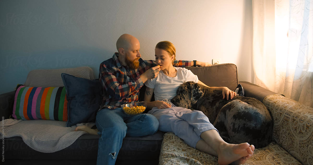 Relaxed couple in living room with dog