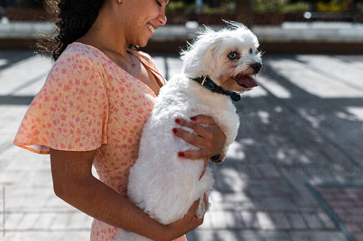 Brown skinned woman holding pet