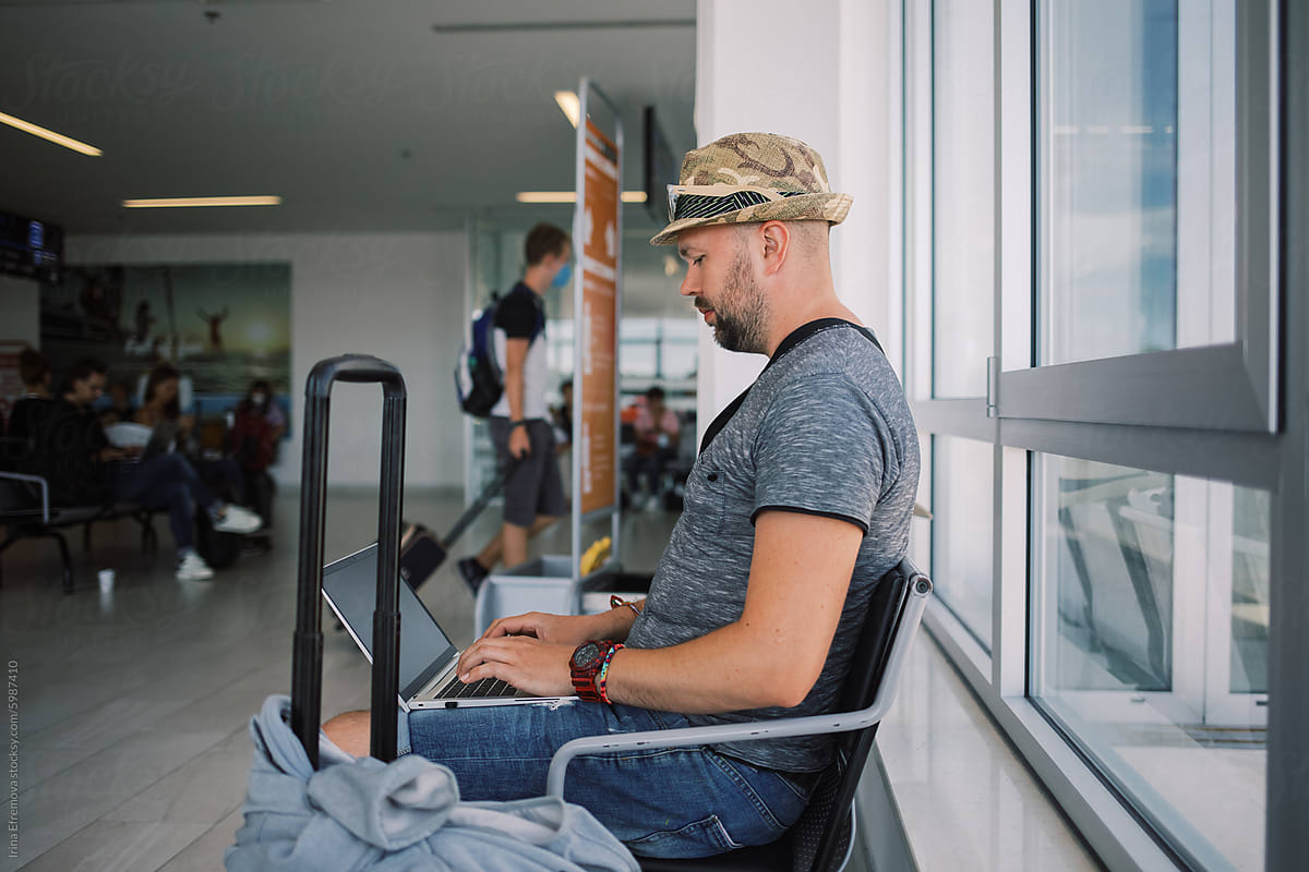 Man Working on Laptop at Airport Gate