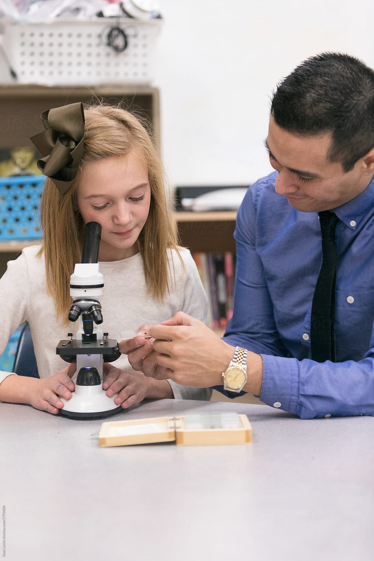 Classroom: Teacher Helps Student With Microscope