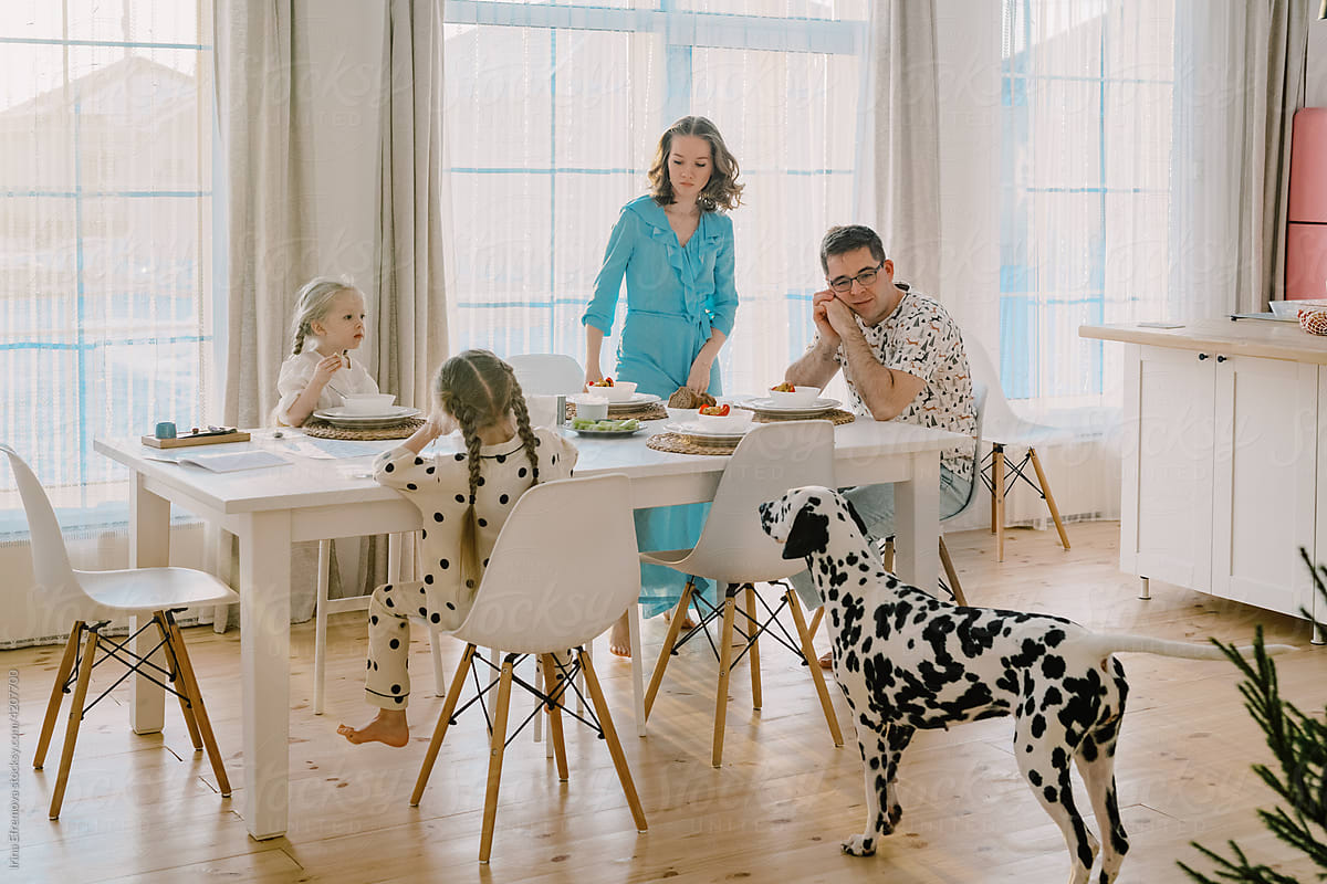 Whole family having dinner in a bright modern kitchen