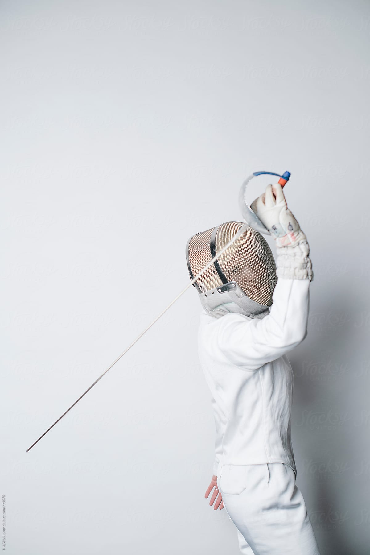 Woman in white fencing costume holding sabre