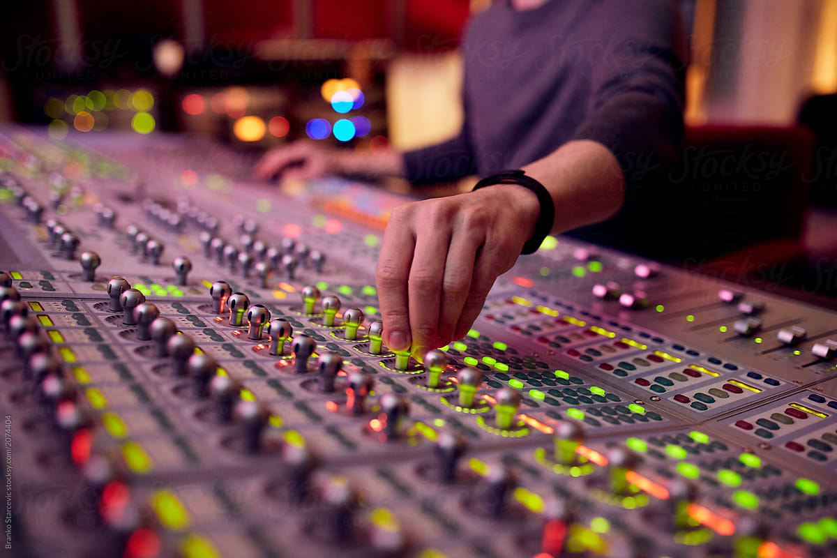 Sound Engineer mixing tracks in music studio.