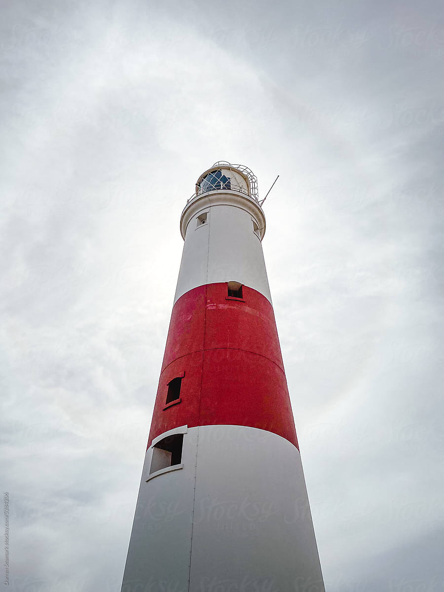 Looking up at a red and white striped lighthouse