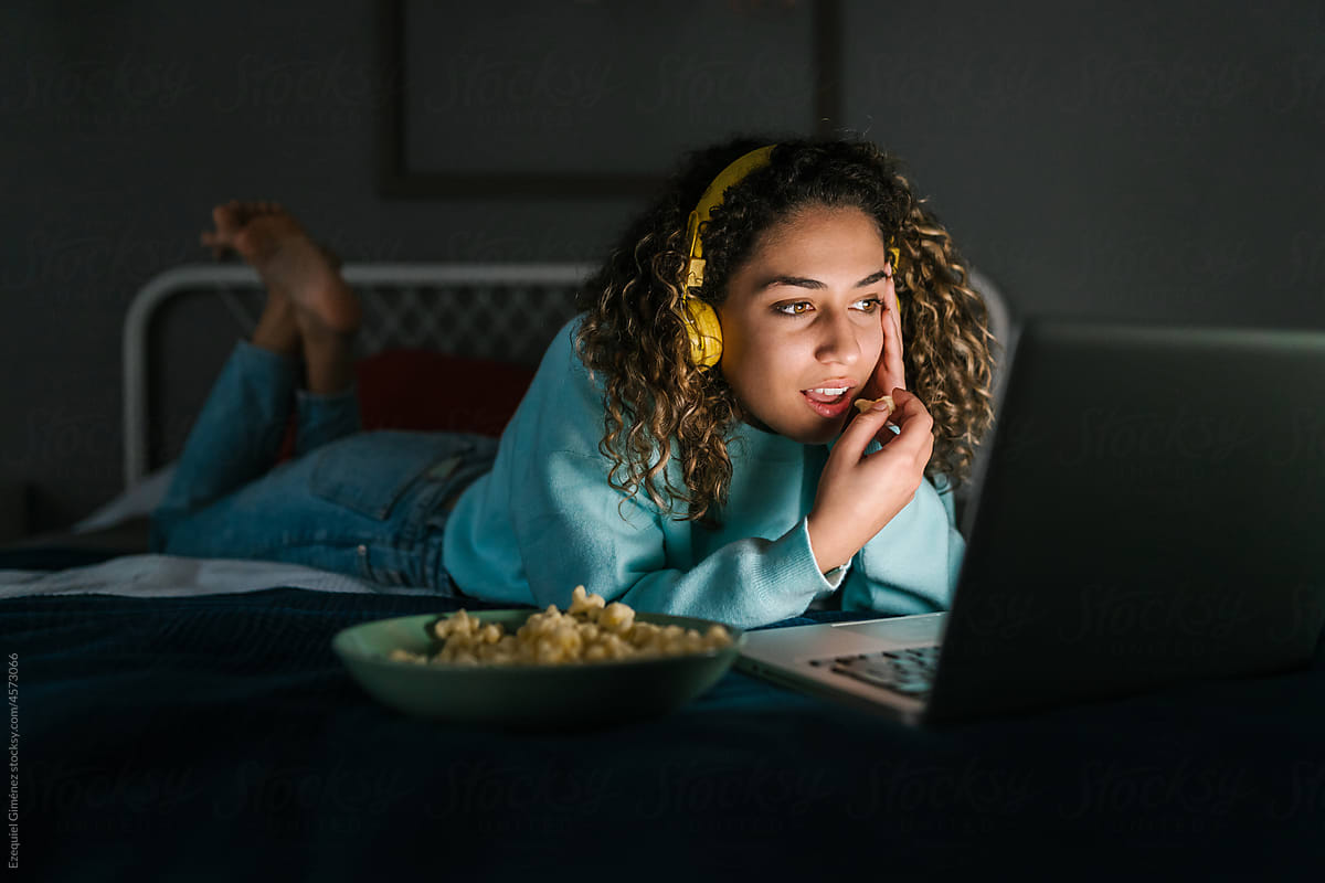 Young woman with popcorn watching interesting movie