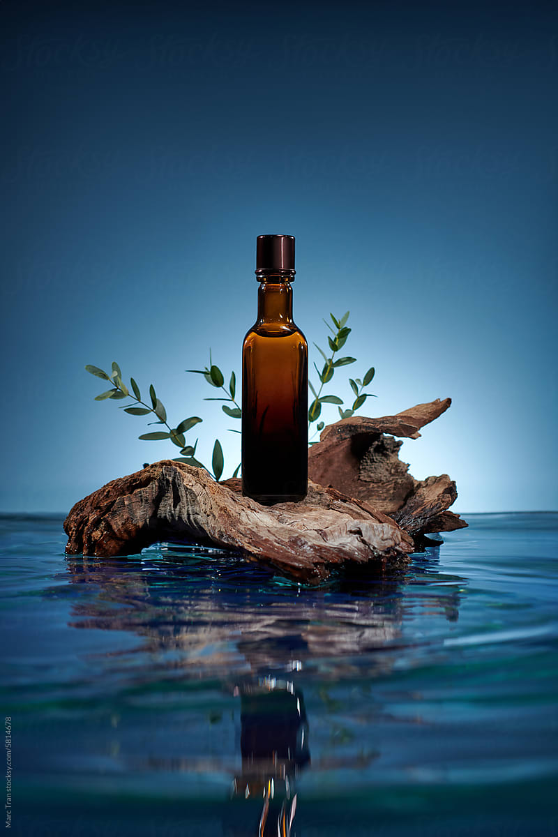 A block of driftwood  with an empty label bottle placed on water