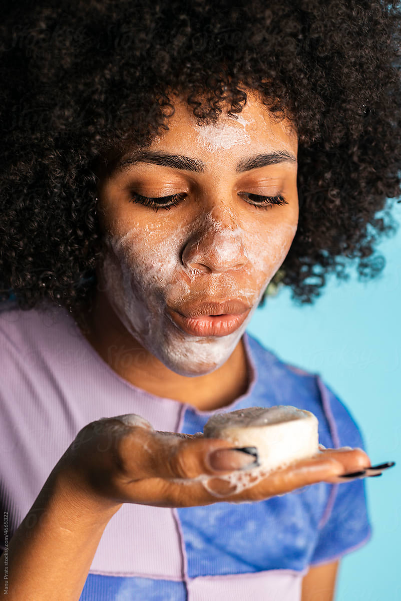 Brown skinned woman cleansing face with handmade soap