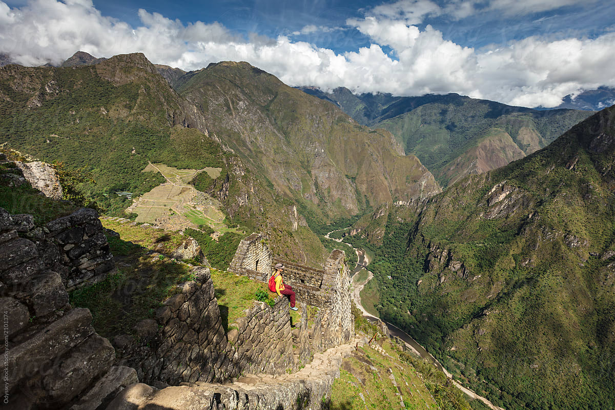 Hiker Sitting on Ruins Looking at View of Peruvian Andes