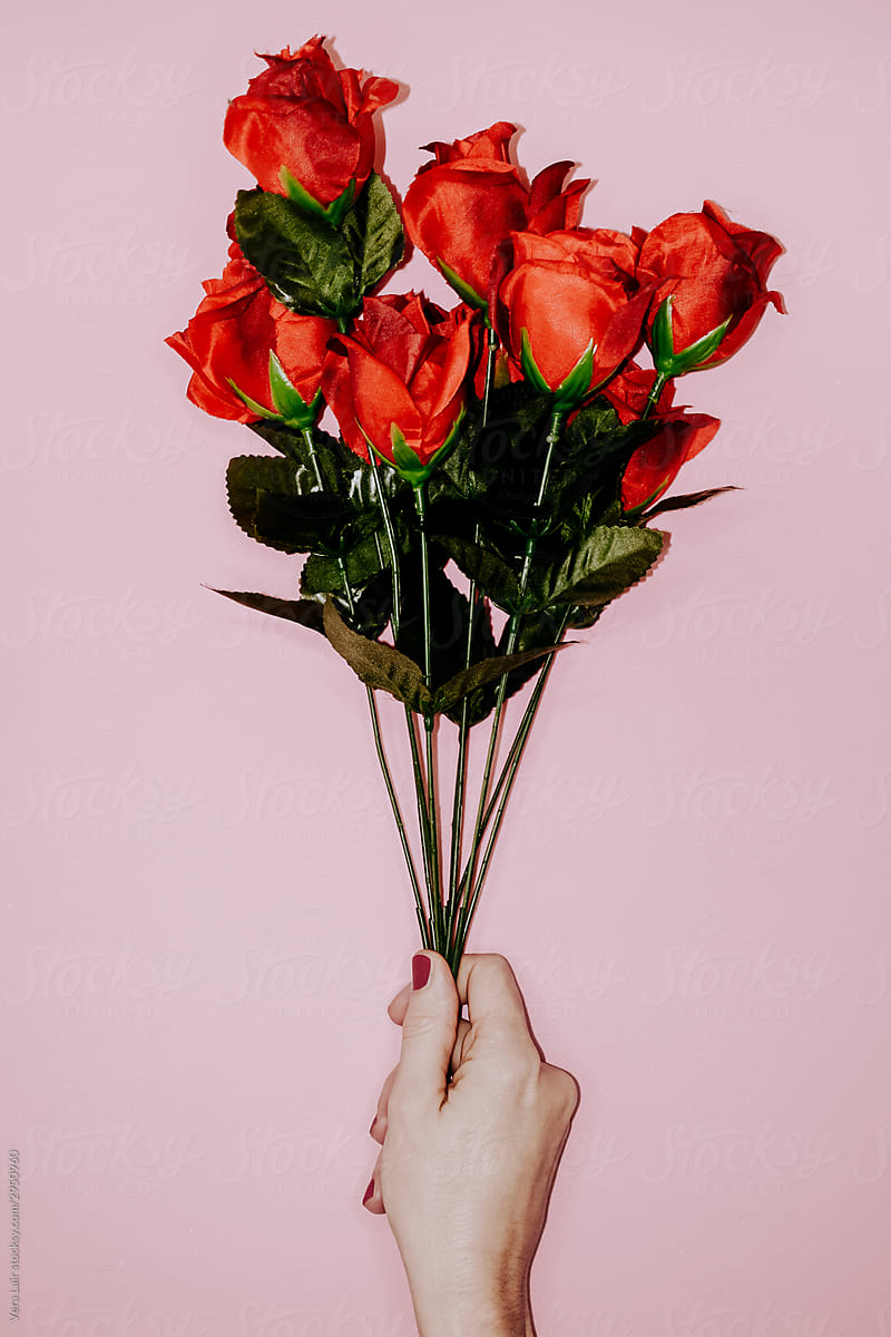 woman hand holding a fake red roses bouquet