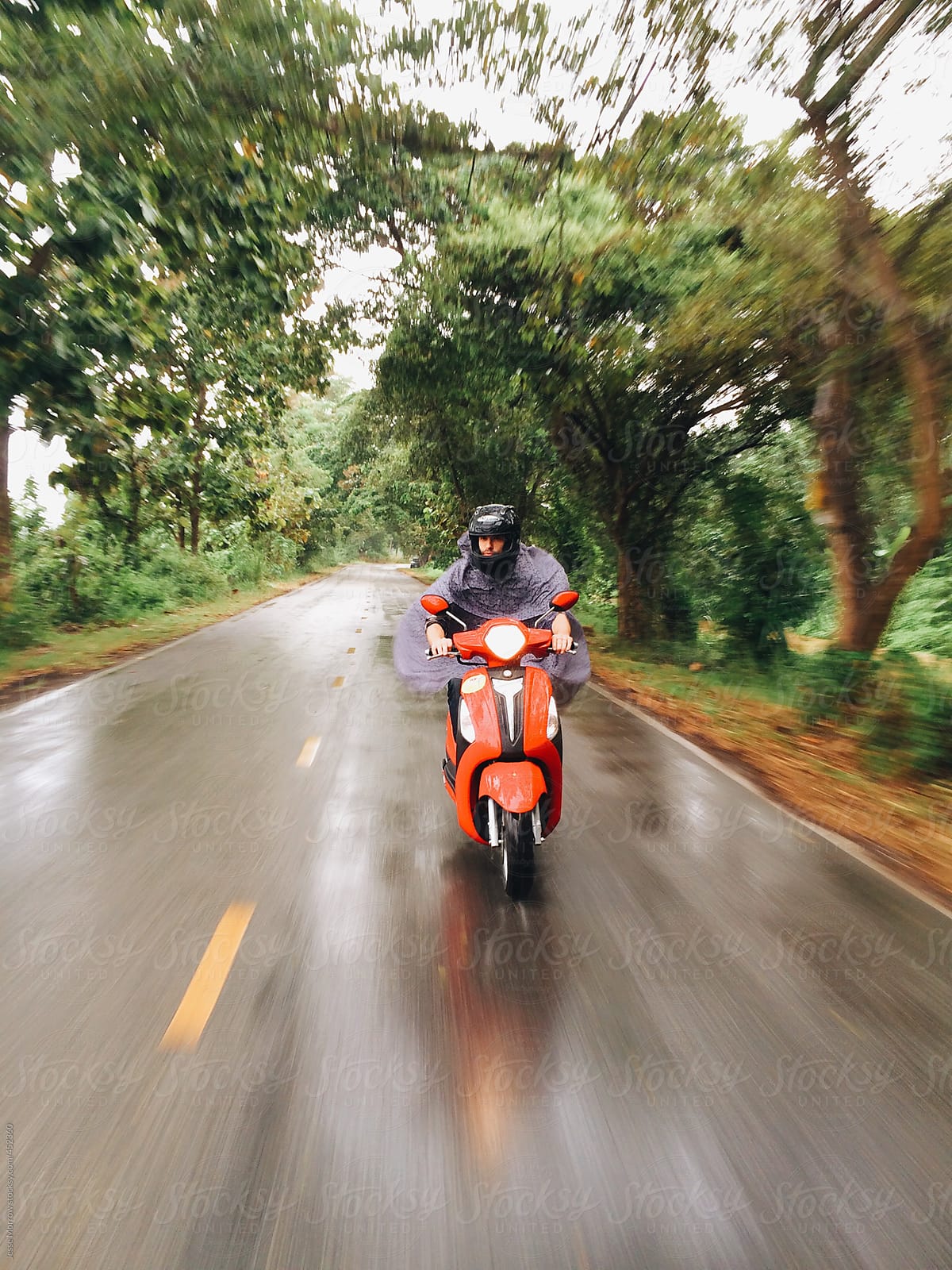 Young man rides moto in rain