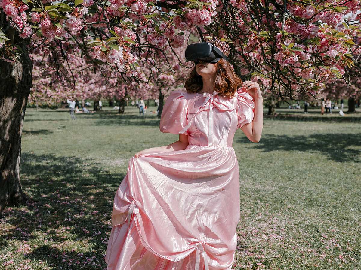 Girl in park in pink dress in using Vr