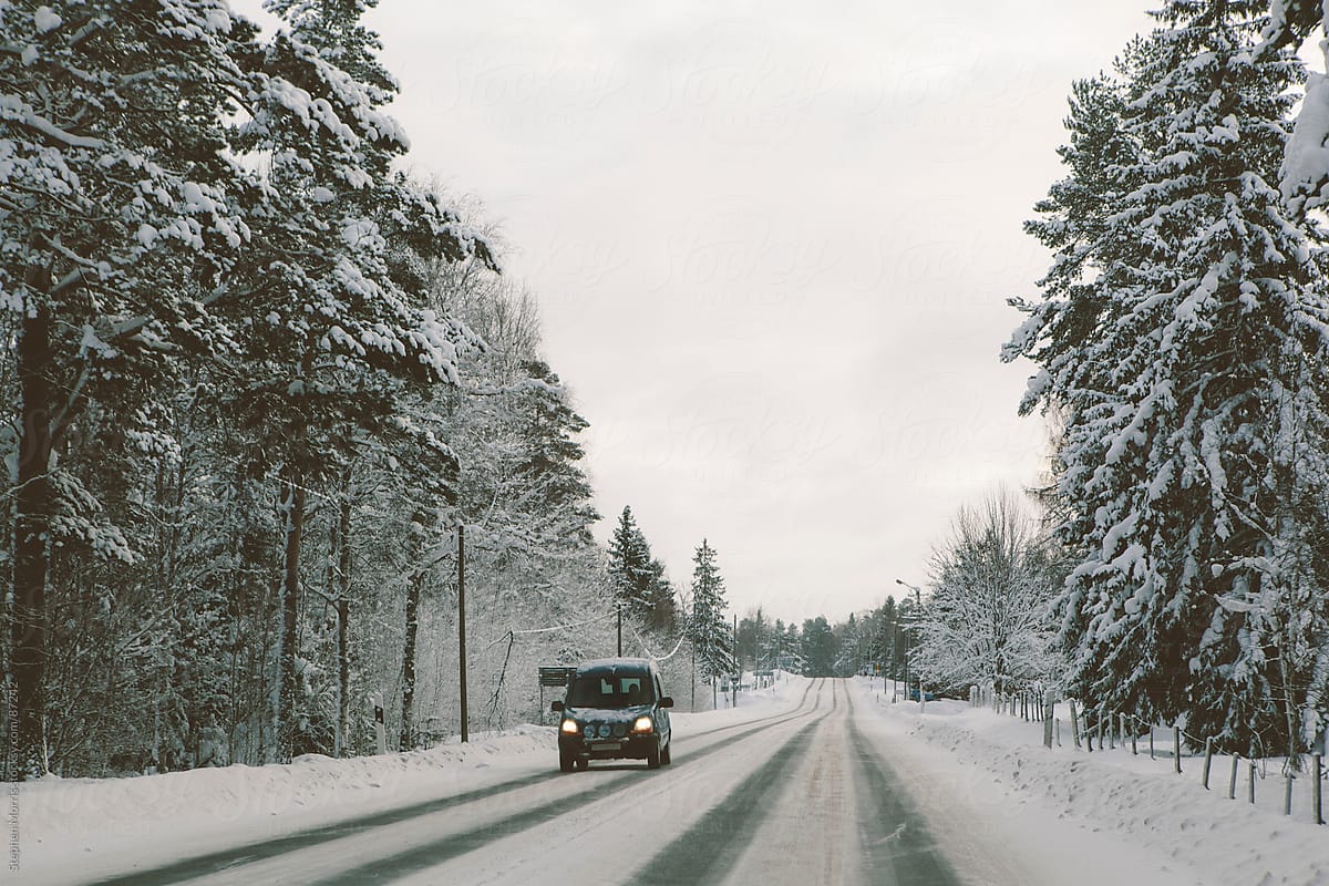 A lone car driving down a snowy Swedish road