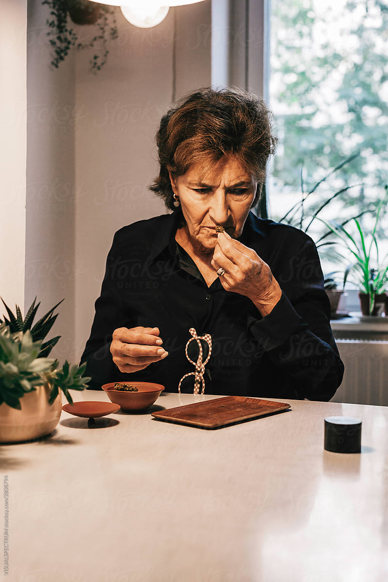 Old Woman Smelling CBD Cannabis at Home