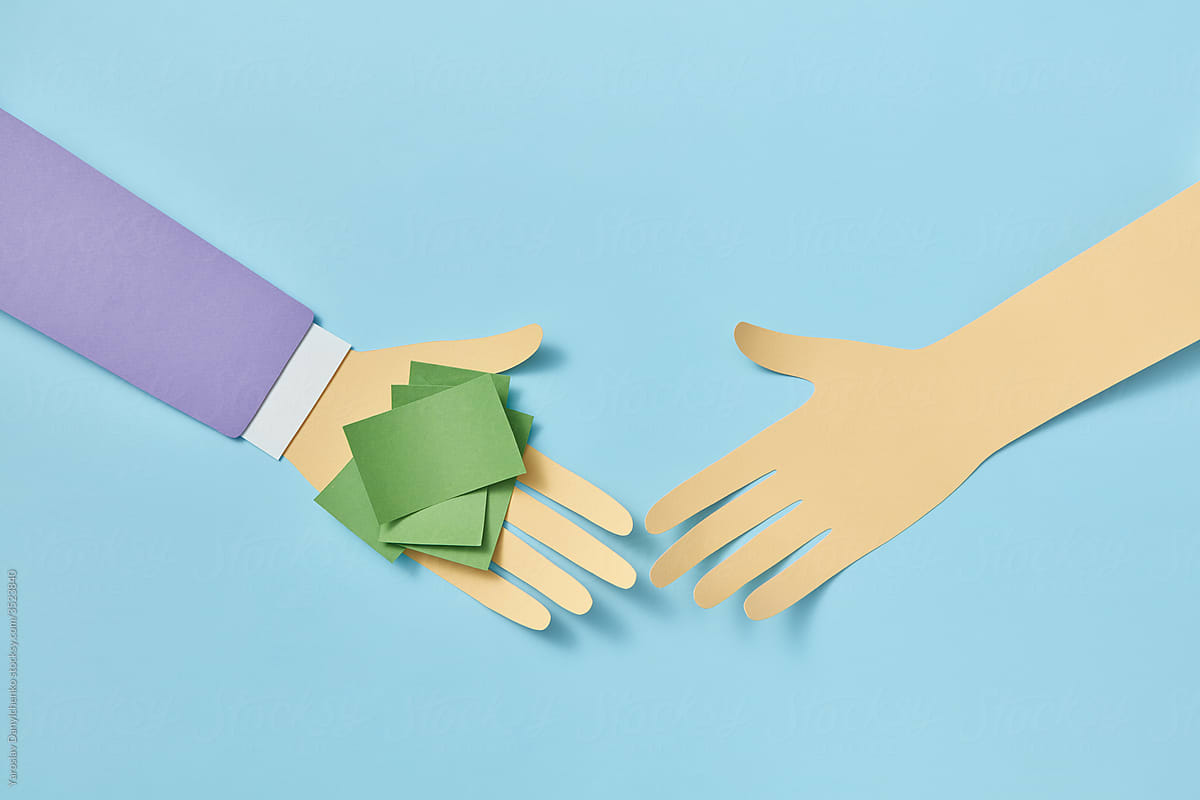 Two papercraft hands with green paper sheets on one.