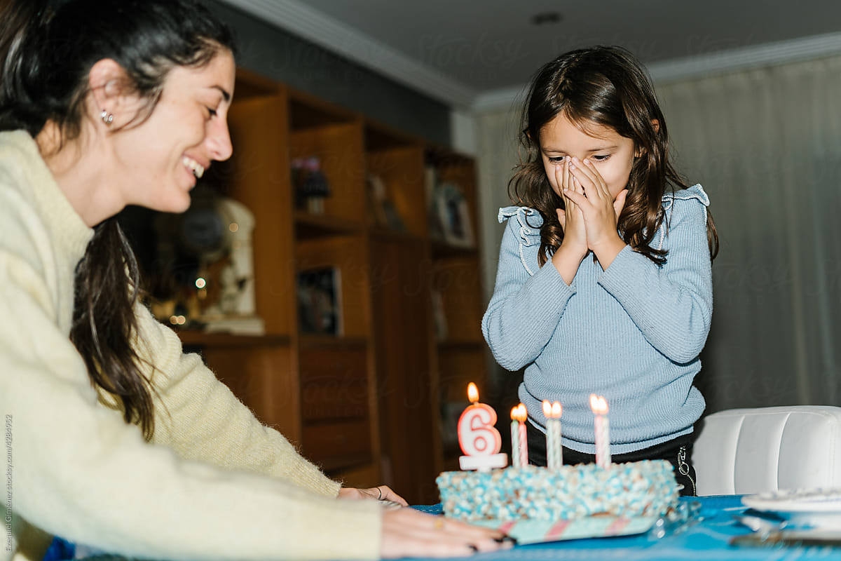 Mother serving birthday cake for daughter