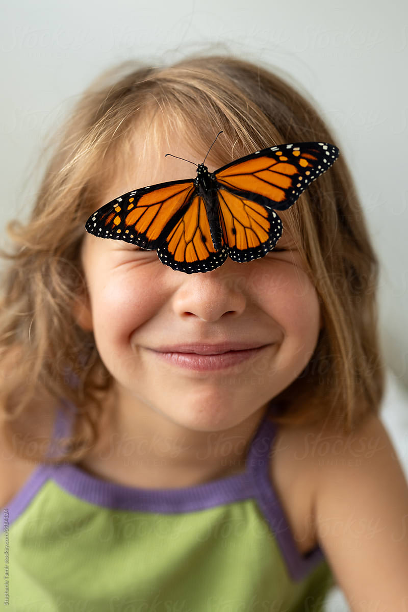 A little girl with a butterfly on her face