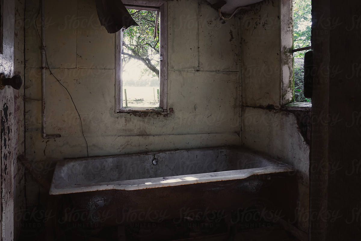 A dirty old bath tub in an abandoned cottage in the countryside