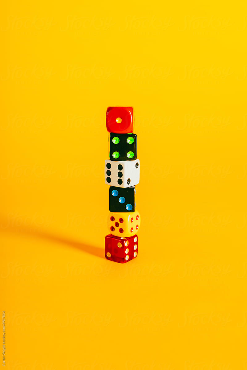Colorful dice pieces on a vibrant yellow background