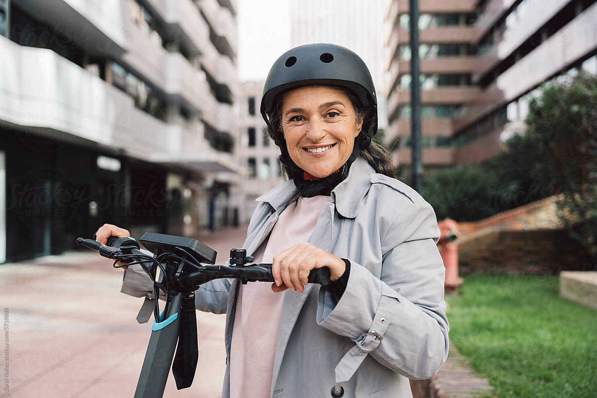 mature woman using electric scooter in the city