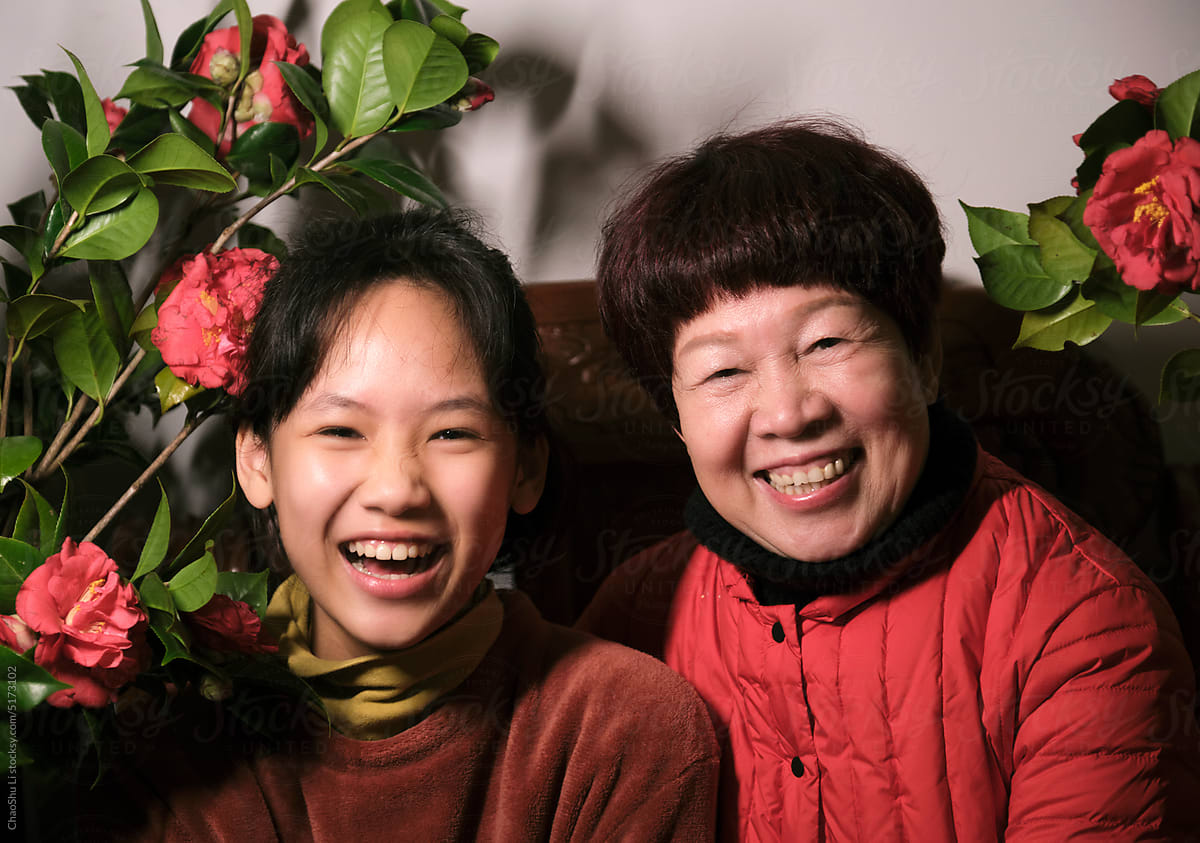 Asian grandchild, in the background of red camellia