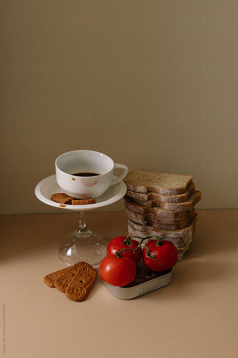 Still life of bread, coffee cup, canned goods and tomatos