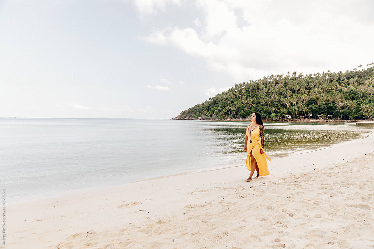 Woman Walking On The Beach In A Yellow Dress By Stocksy Contributor