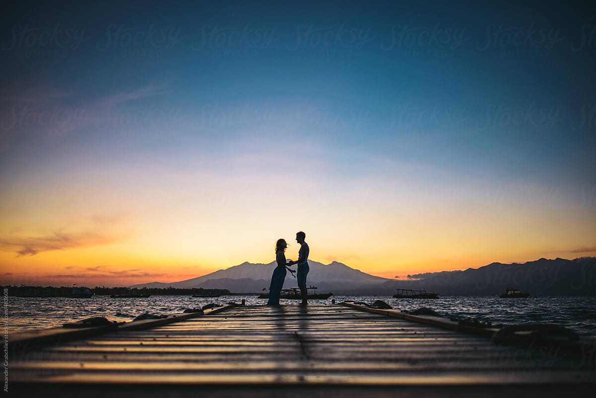 Young Couple Silhouette On The Beach At Sunset By Alexander Grabchilev Stocksy United