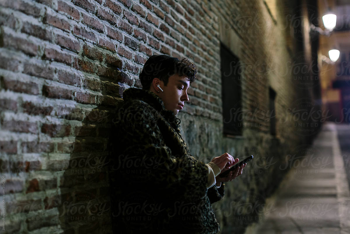 Young person listening to music in city night lights