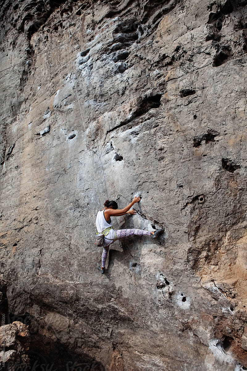 Climbing woman on rocky cliff