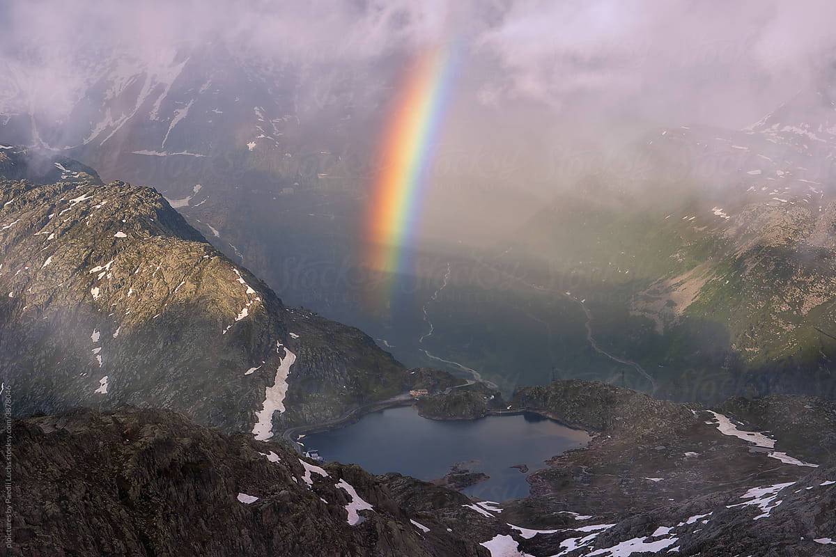 Rainbow, lake and rainy weather in the alps