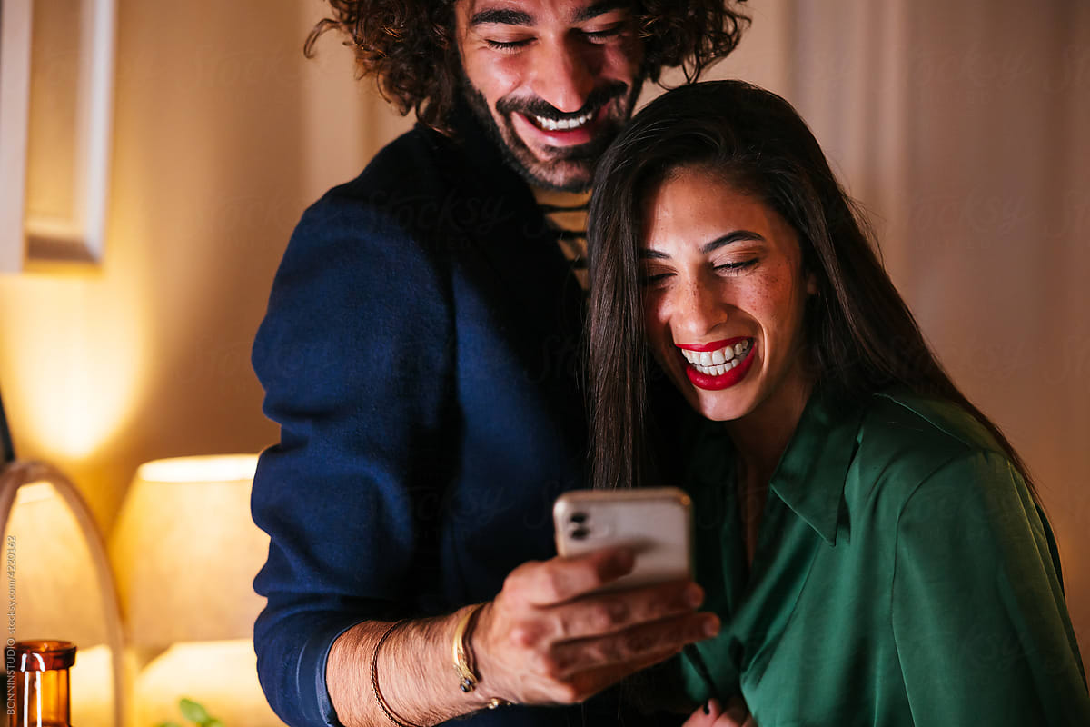Happy multiracial friends using smartphone together