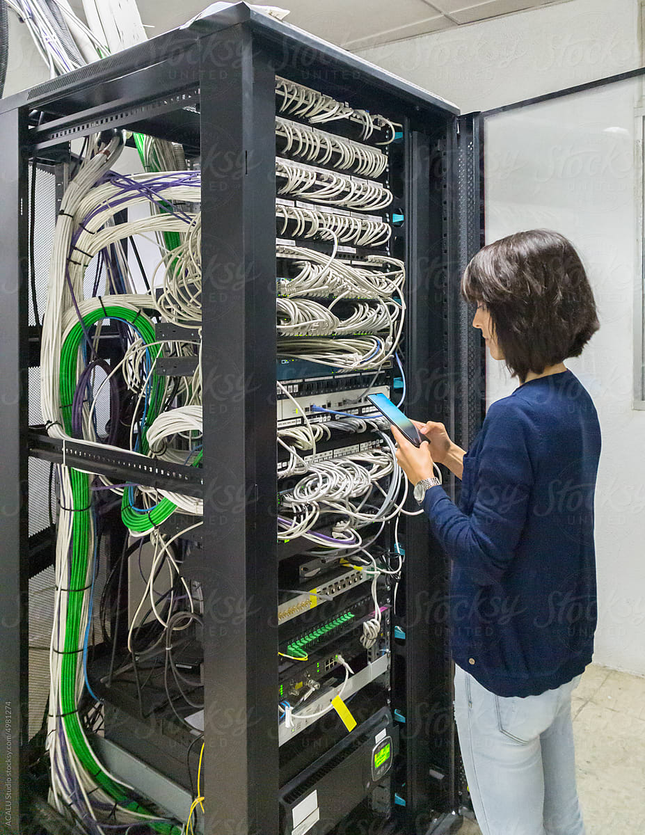 Engineer woman working in a datacenter with a mobile phone