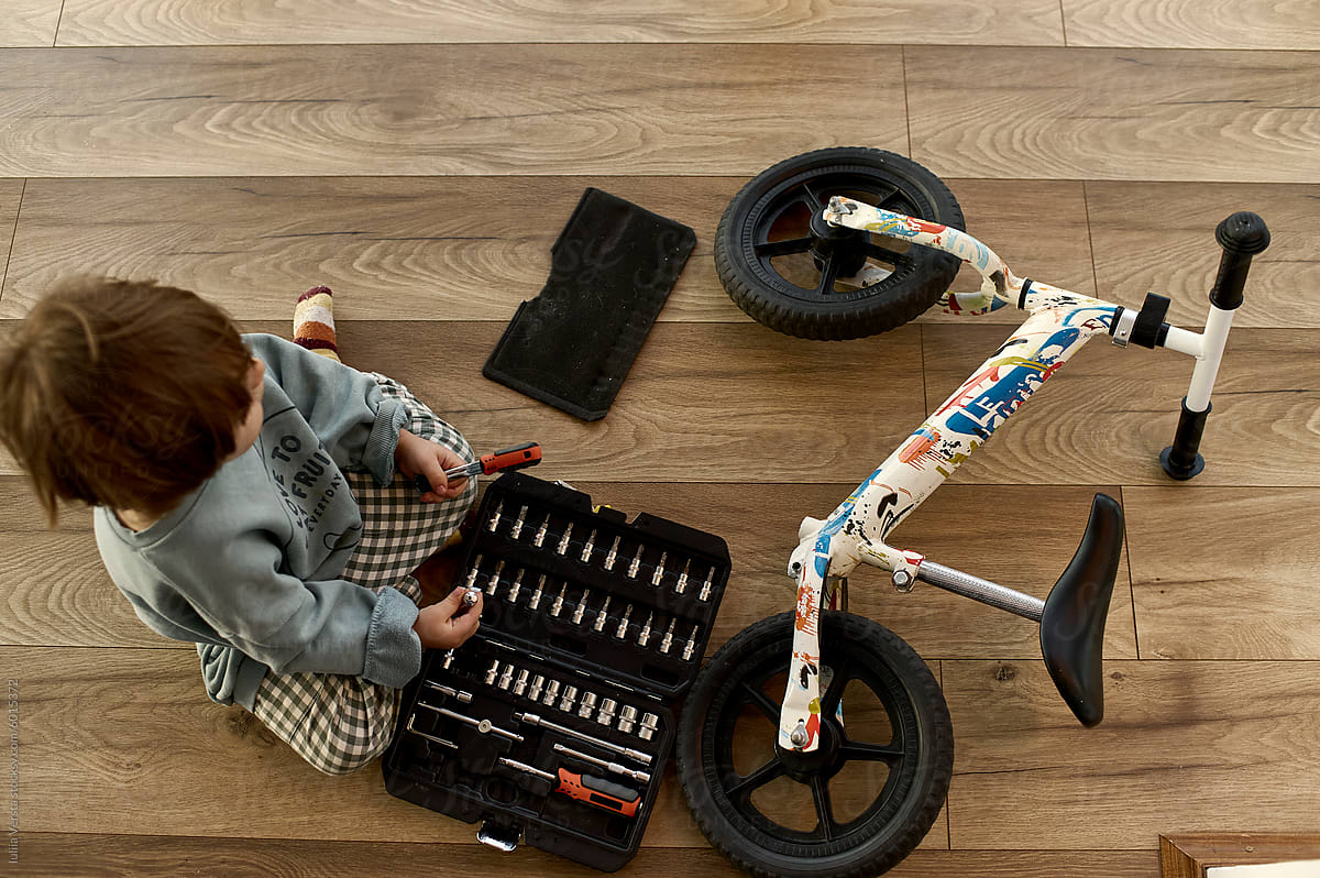 little boy repairing a bicycle