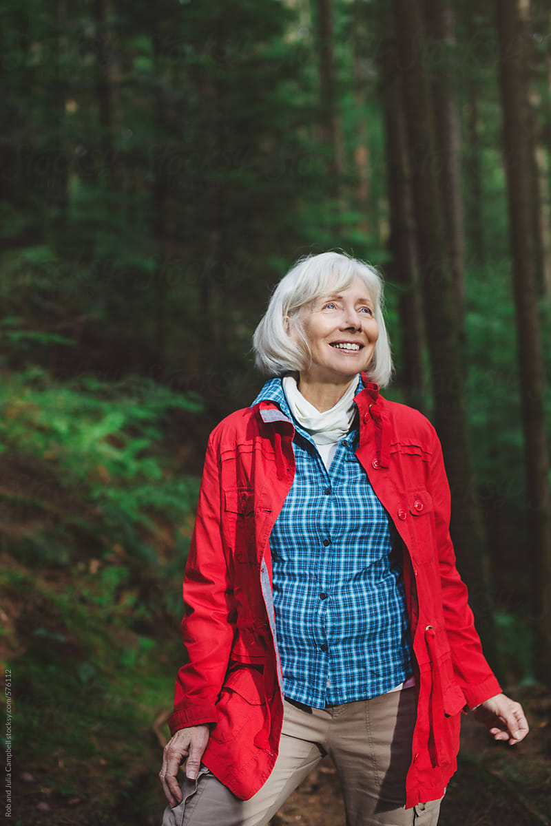 Attractive mature woman on a hike through old growth forest