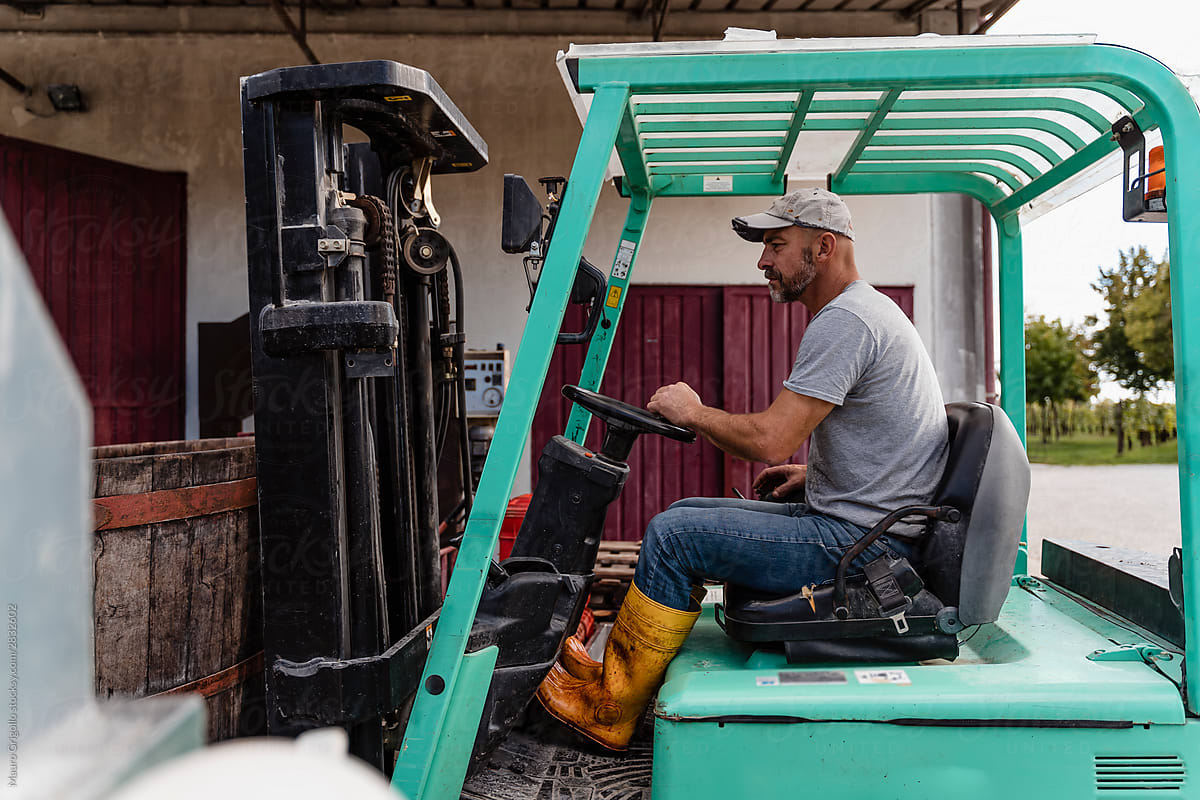 Farmer driving a forklift on his farm on a working day